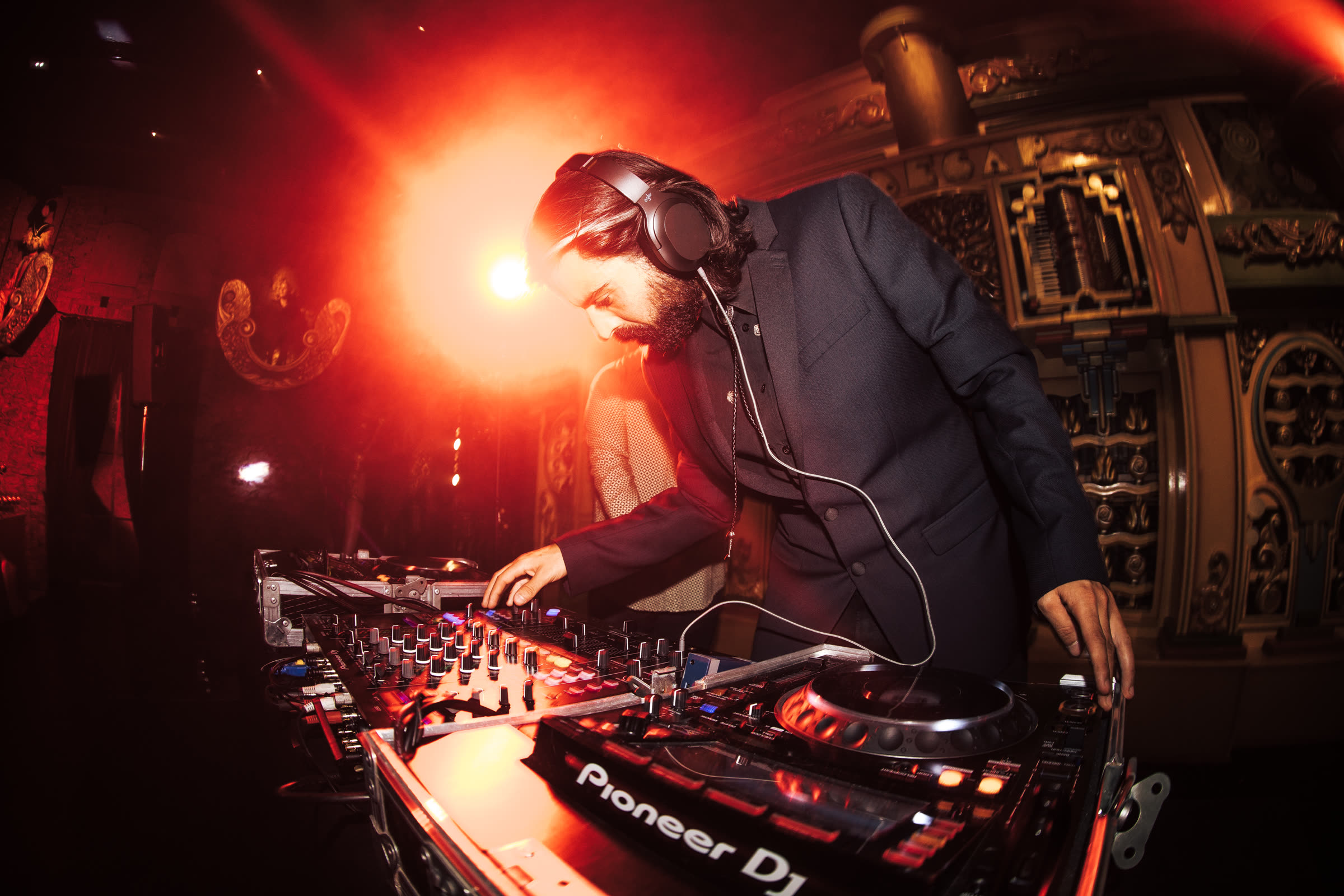 ZANAVI mixing on Pioneer decks under warm red stage light